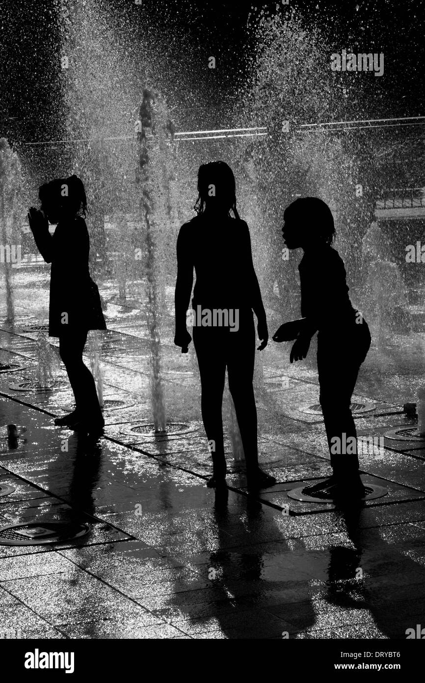 Silhouettes of children playing in water fountains Stock Photo - Alamy
