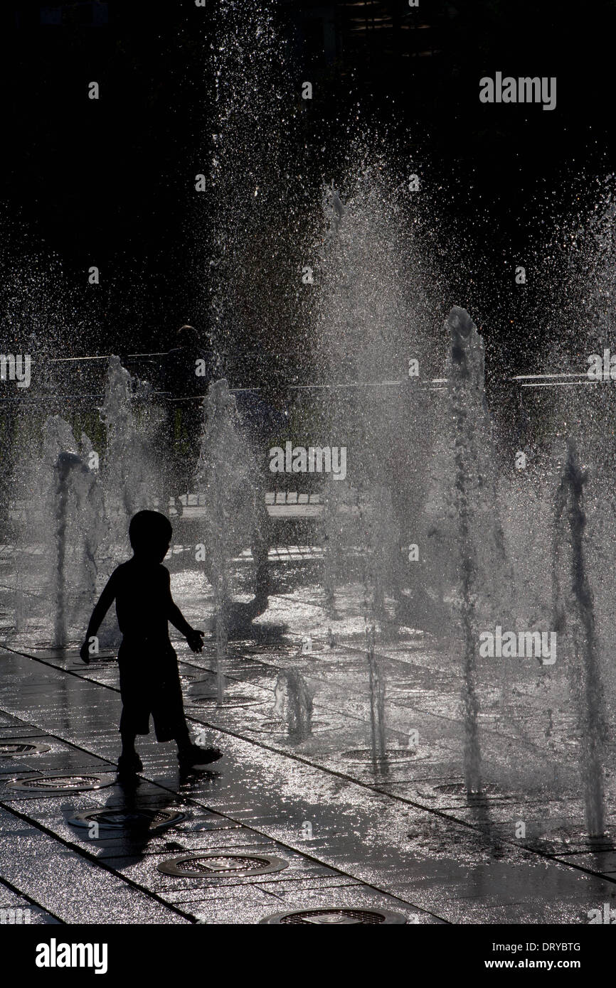 Silhouette of child playing in water fountains Stock Photo - Alamy