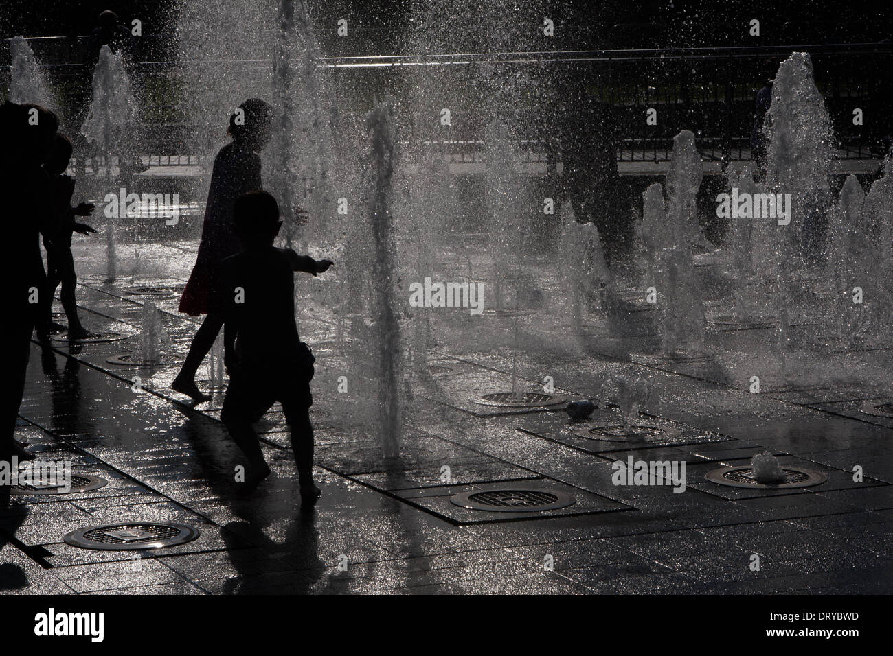 Silhouettes of people playing in water fountains Stock Photo - Alamy