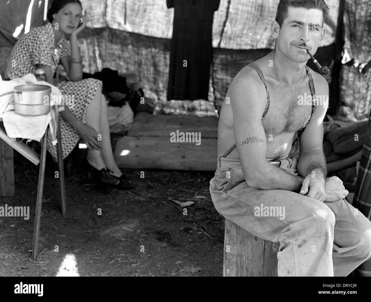 Unemployed lumber worker goes with his wife to a bean harvest, note the social security number tattooed on his arm, Oregon, USA Stock Photo