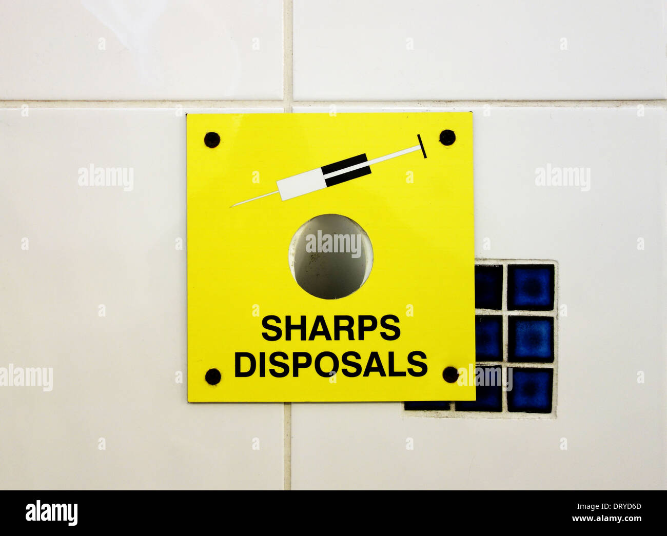 a used hypodermic needle disposal unit in a gents toilet Stock Photo