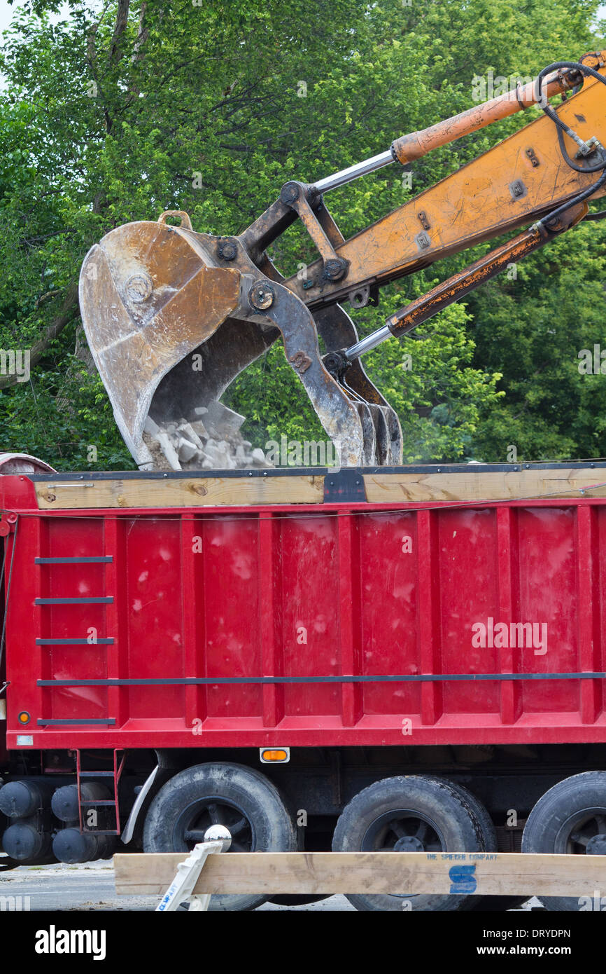 Closeup of Backhoe loade.Digger bucked.Excavator loads rubble on drump truck from side nobody vertical hi-res Stock Photo