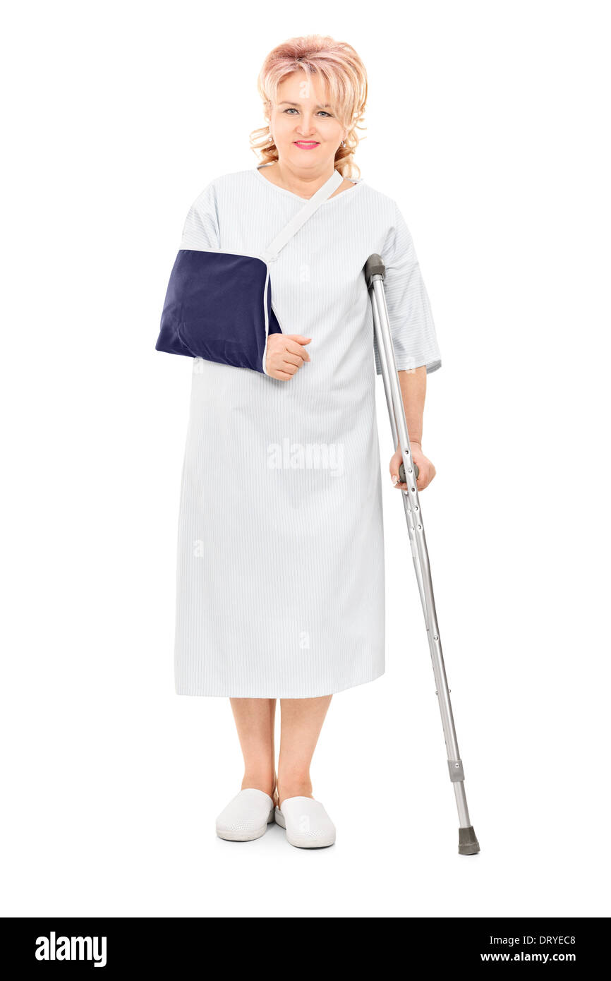 Full length portrait of female patient with broken arm standing with a crutch Stock Photo