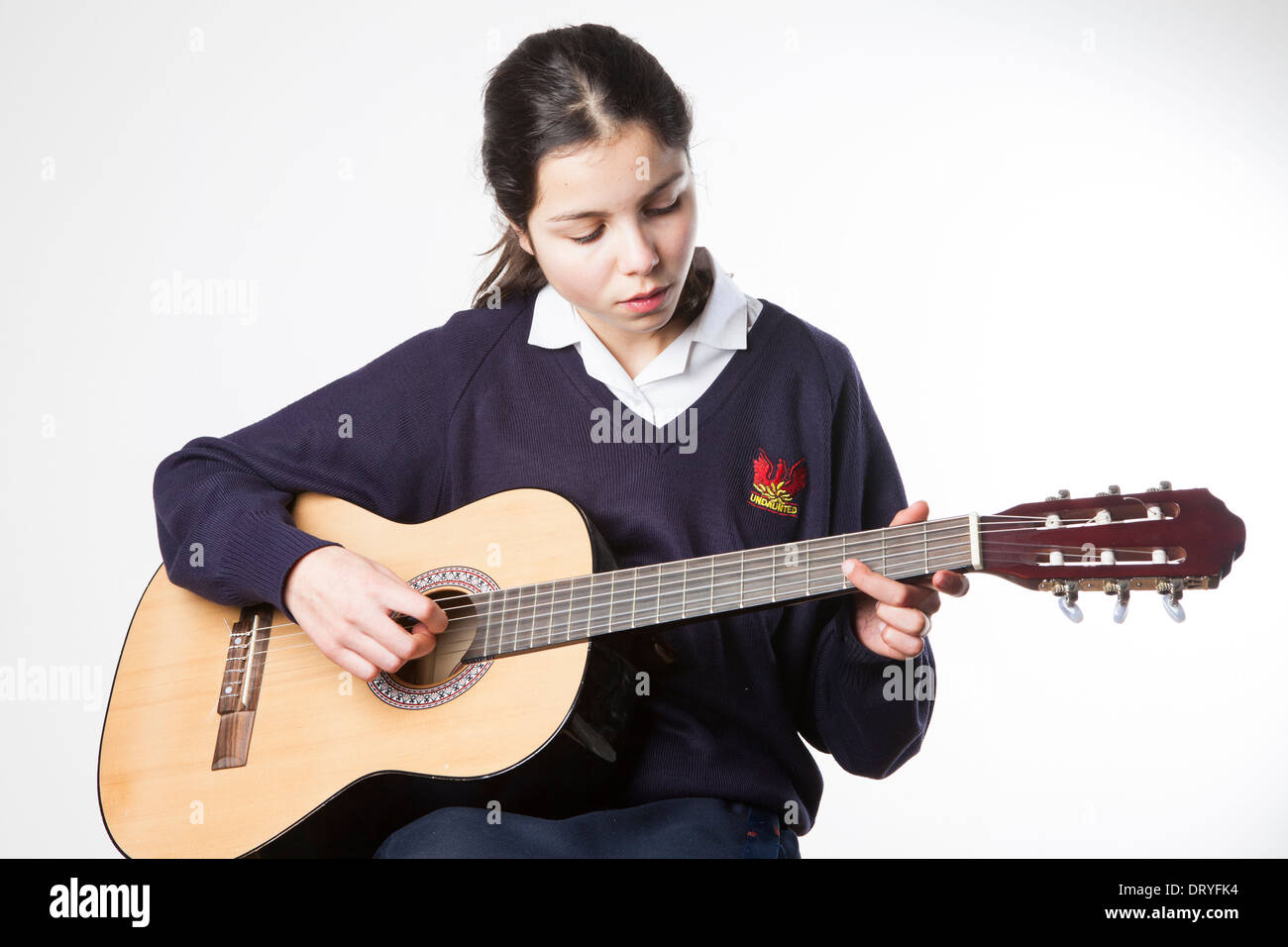 Teenage schoolgirl plays acoustic guitar Stock Photo