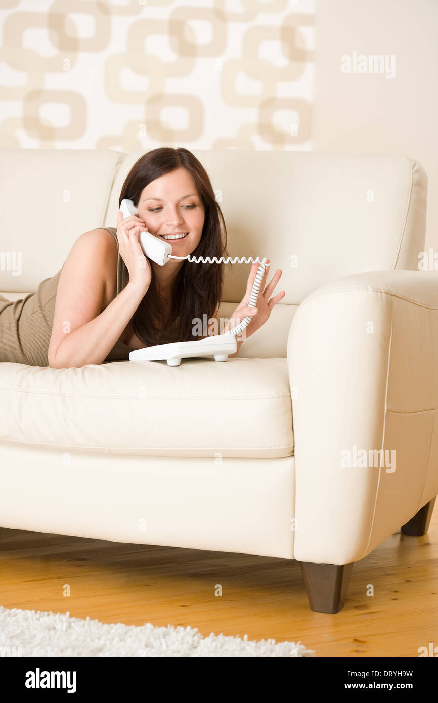 On the phone: young woman calling in lounge Stock Photo