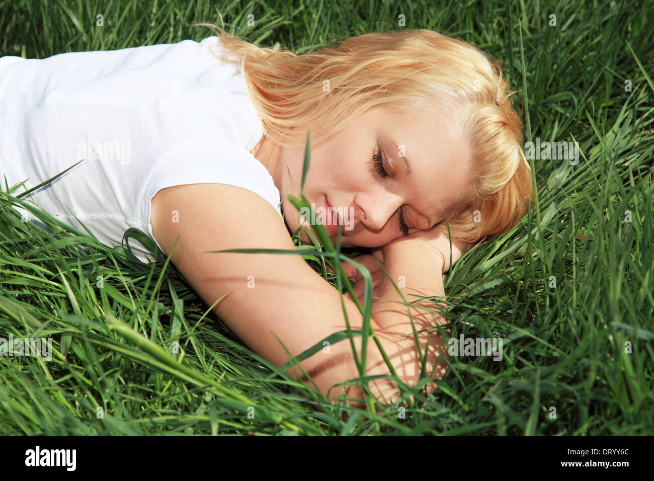 Attractive woman relaxing outside on green meadow. Stock Photo