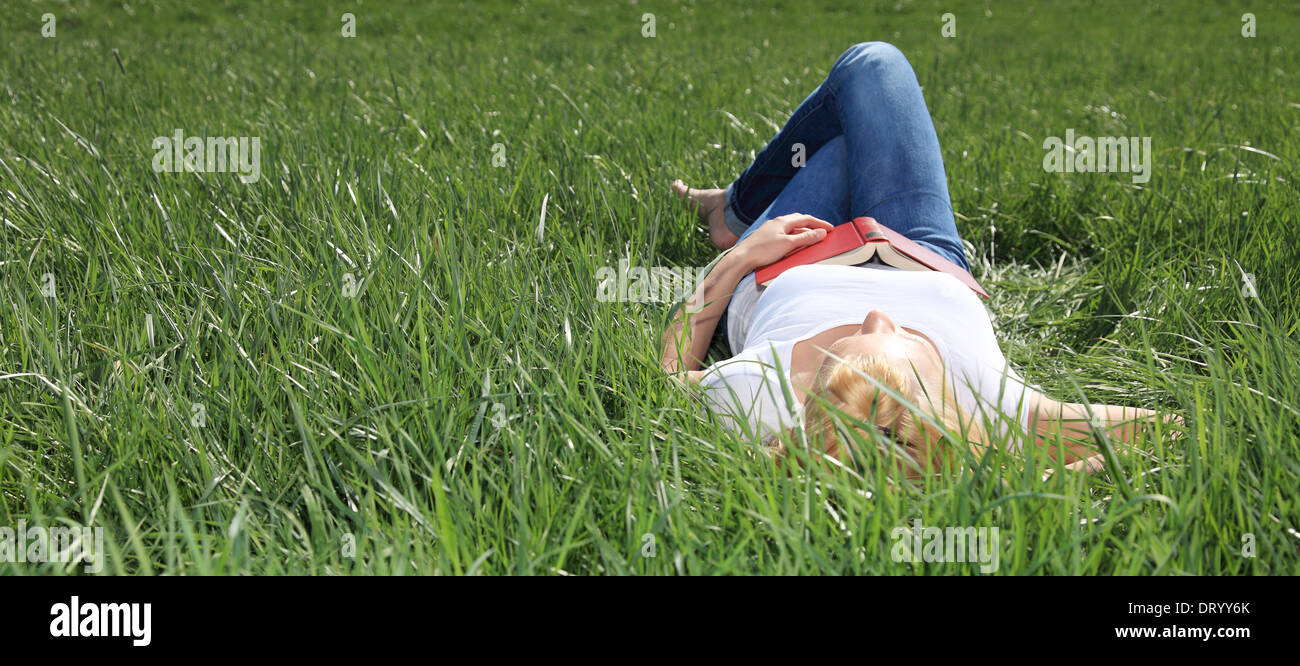 Attractive woman relaxing outside on green meadow. Stock Photo