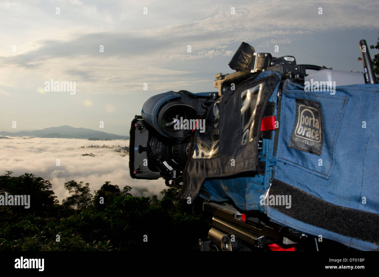 Video camera filming sunrise with low clouds covering valley, Danum Valley, Sabah, East Malaysia, Borneo Stock Photo