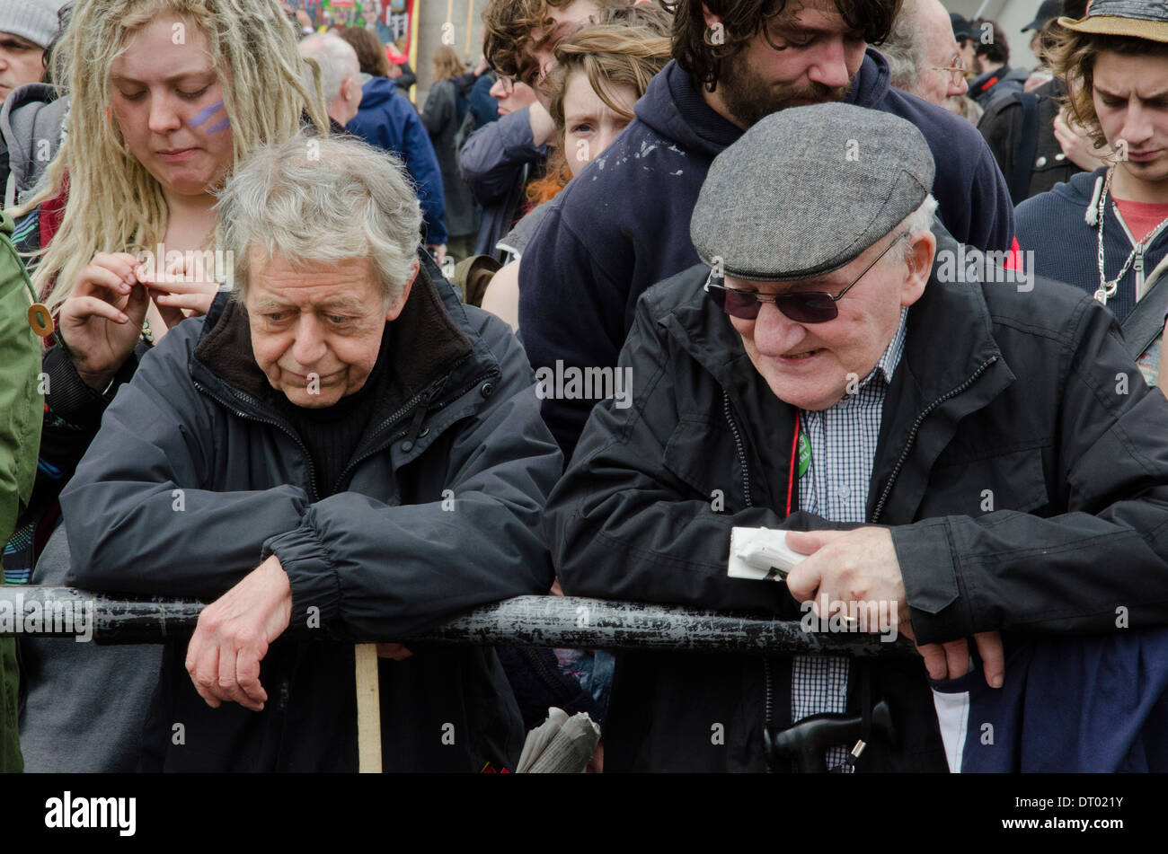 TWO ELDERLY MAN LOOKING DOWN AND CHATTING DURING THE PUBLIC SPENDING CUTS DEMO IN TRAFALGAR SQUARE Stock Photo