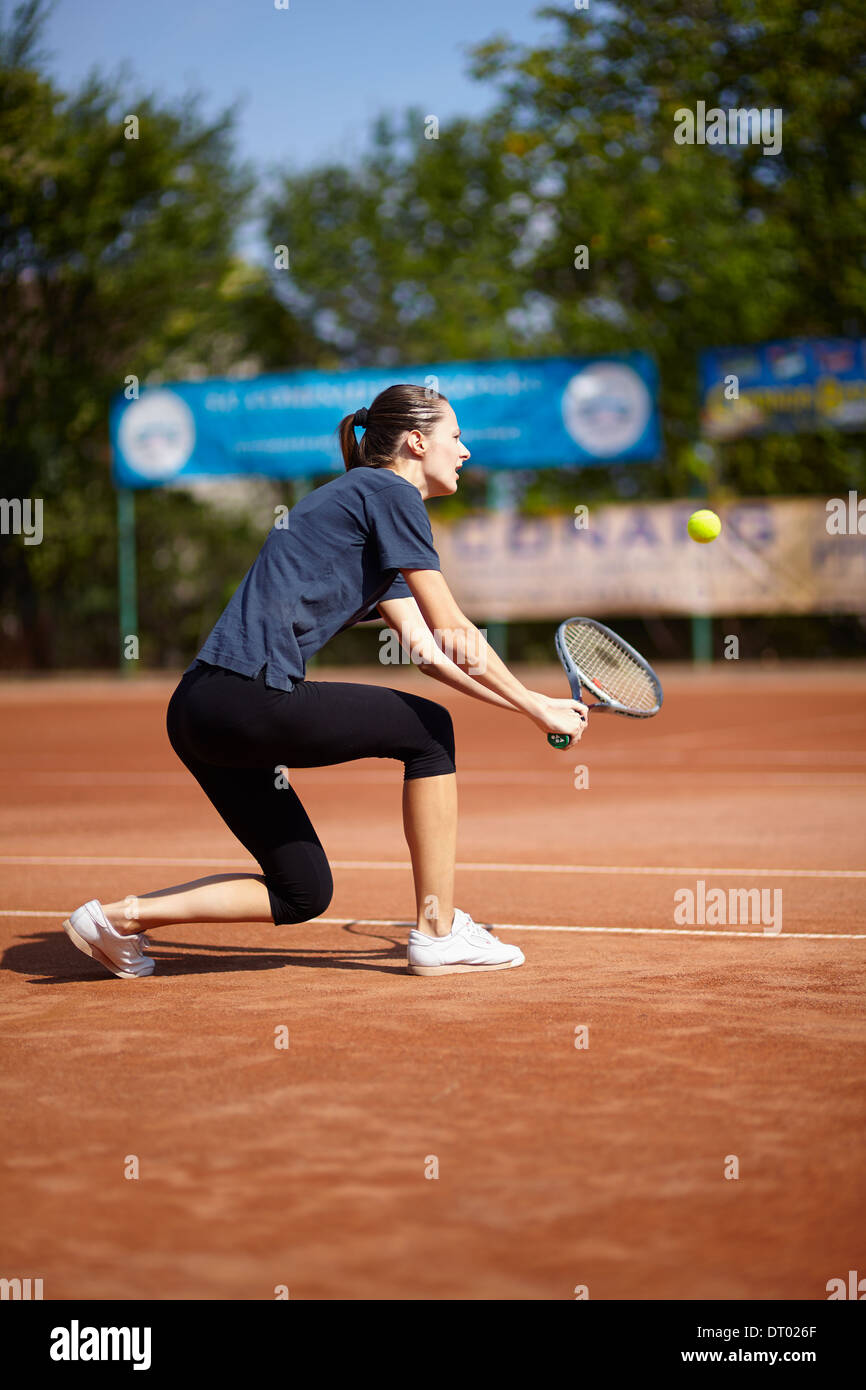 Female tennis player executing a backhand volley Stock Photo