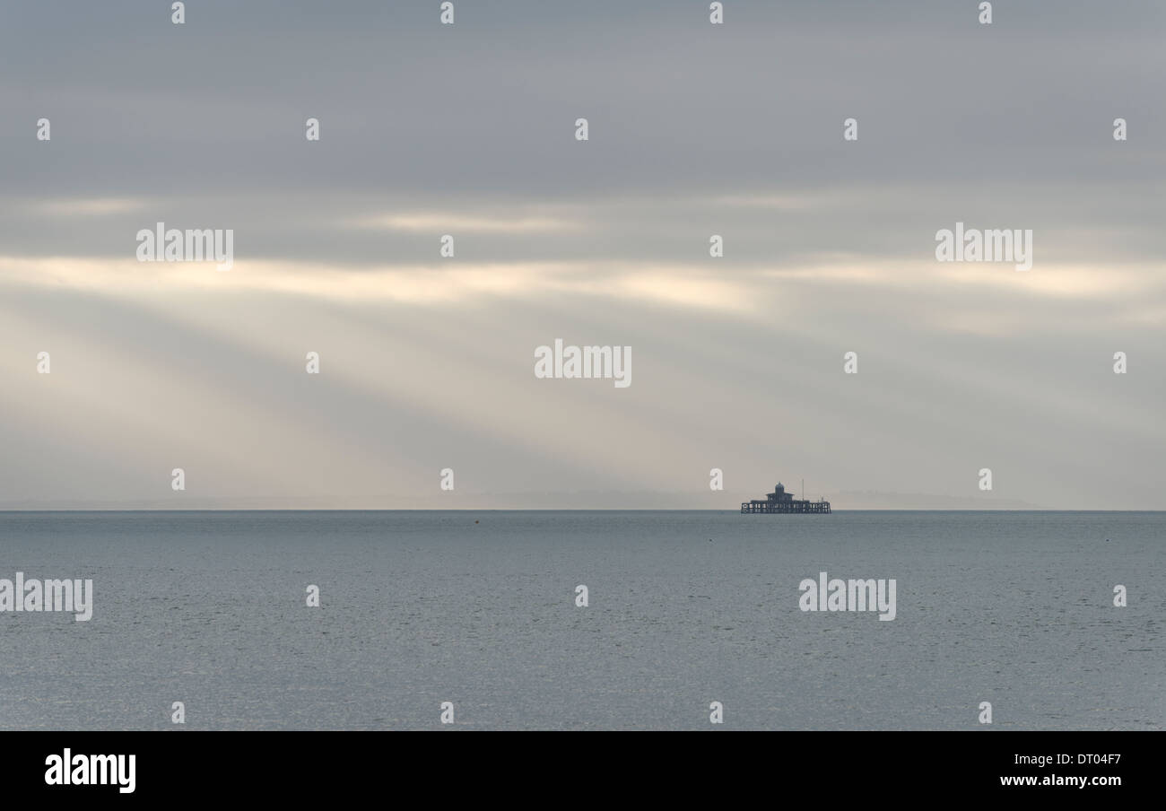 Sun Rays Diagonal The Herne Bay pier head, isolated at sea with diagonal sun rays behind ...