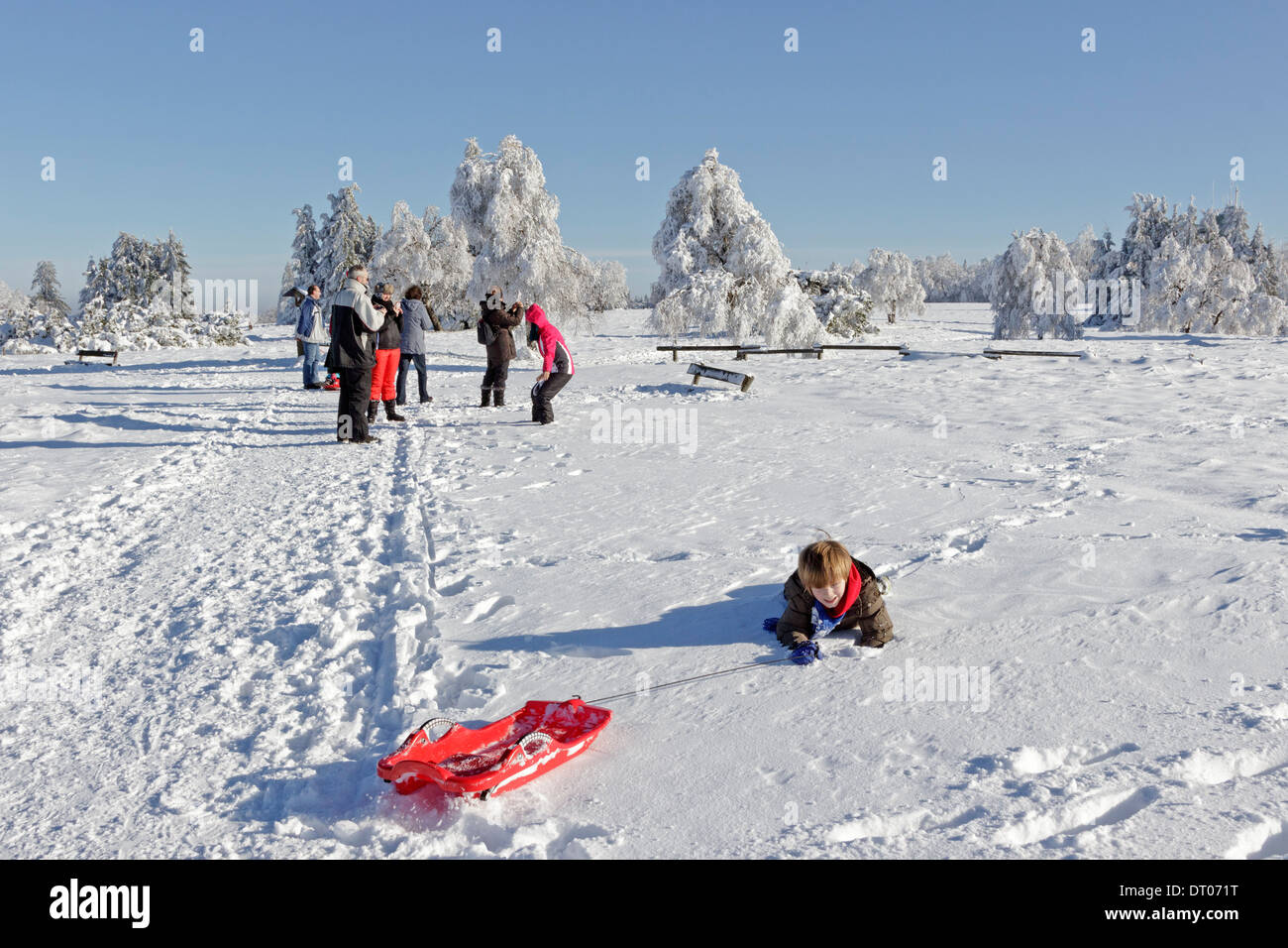 young boy with his sled lying in the snow, Kahler Asten, Sauerland, North Rhine-Westfalia, Germany Stock Photo