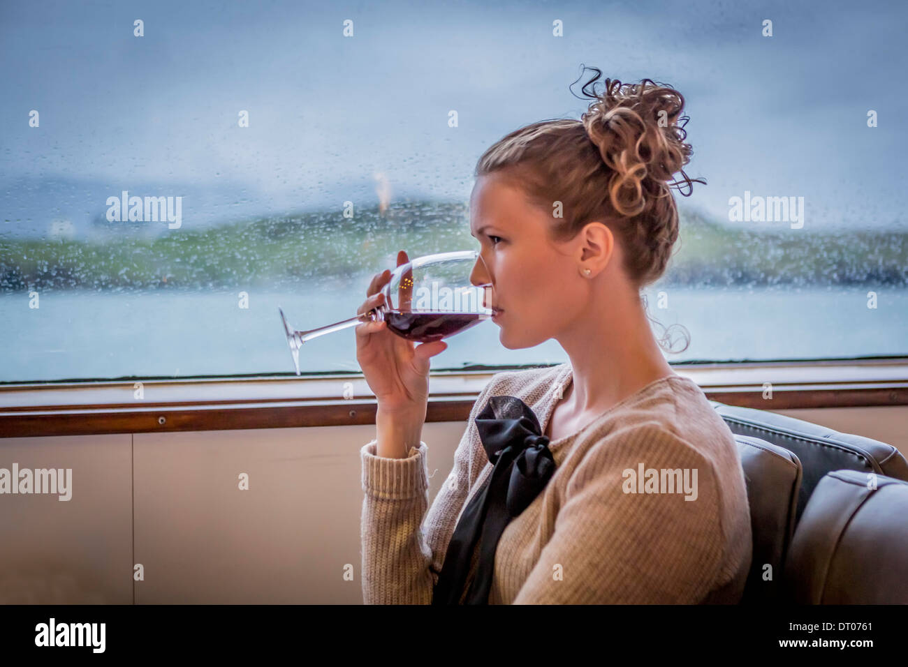Woman having a glass of red wine on a dinner cruise around Reykjavik Harbor, Reykjavik, Iceland Stock Photo