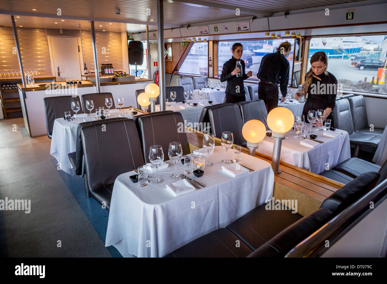 Waiters setting up for a dinner cruise around Reykjavik Harbor, Reykjavik, Iceland Stock Photo