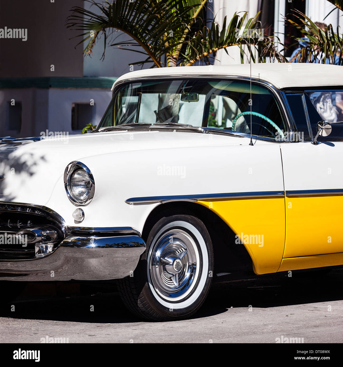 Old white and yellow car in the street Stock Photo