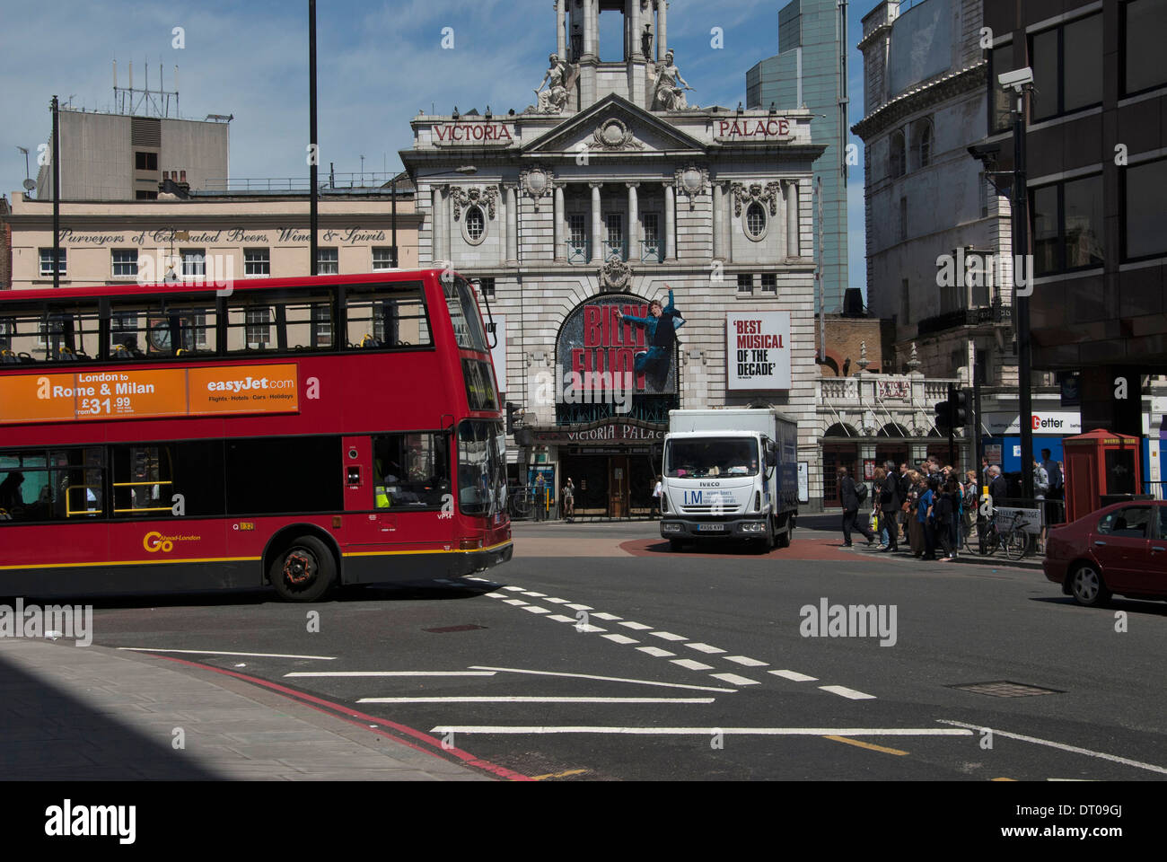 London red double decker bus passing in front of the Victoria Palace Theatre, Victoria Street. Stock Photo