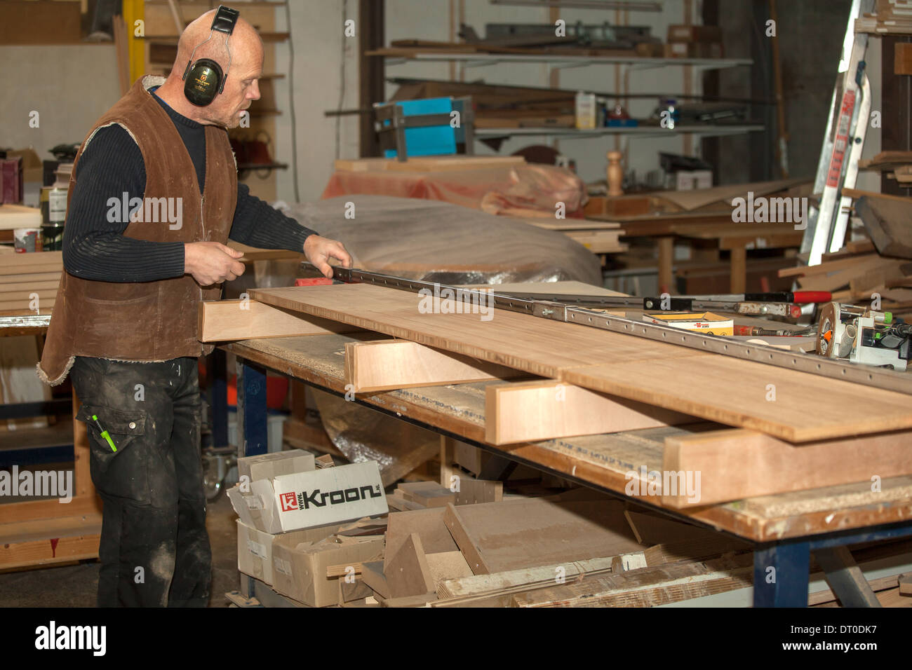 Carpenter joining two large pieces of wood using screw clamp in the