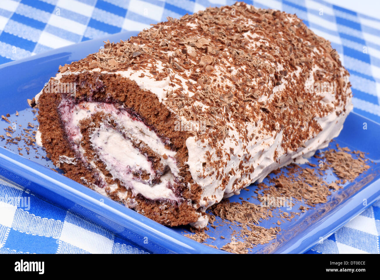 Chocolate swiss roll cake with berries jam and whipped cream over a ...