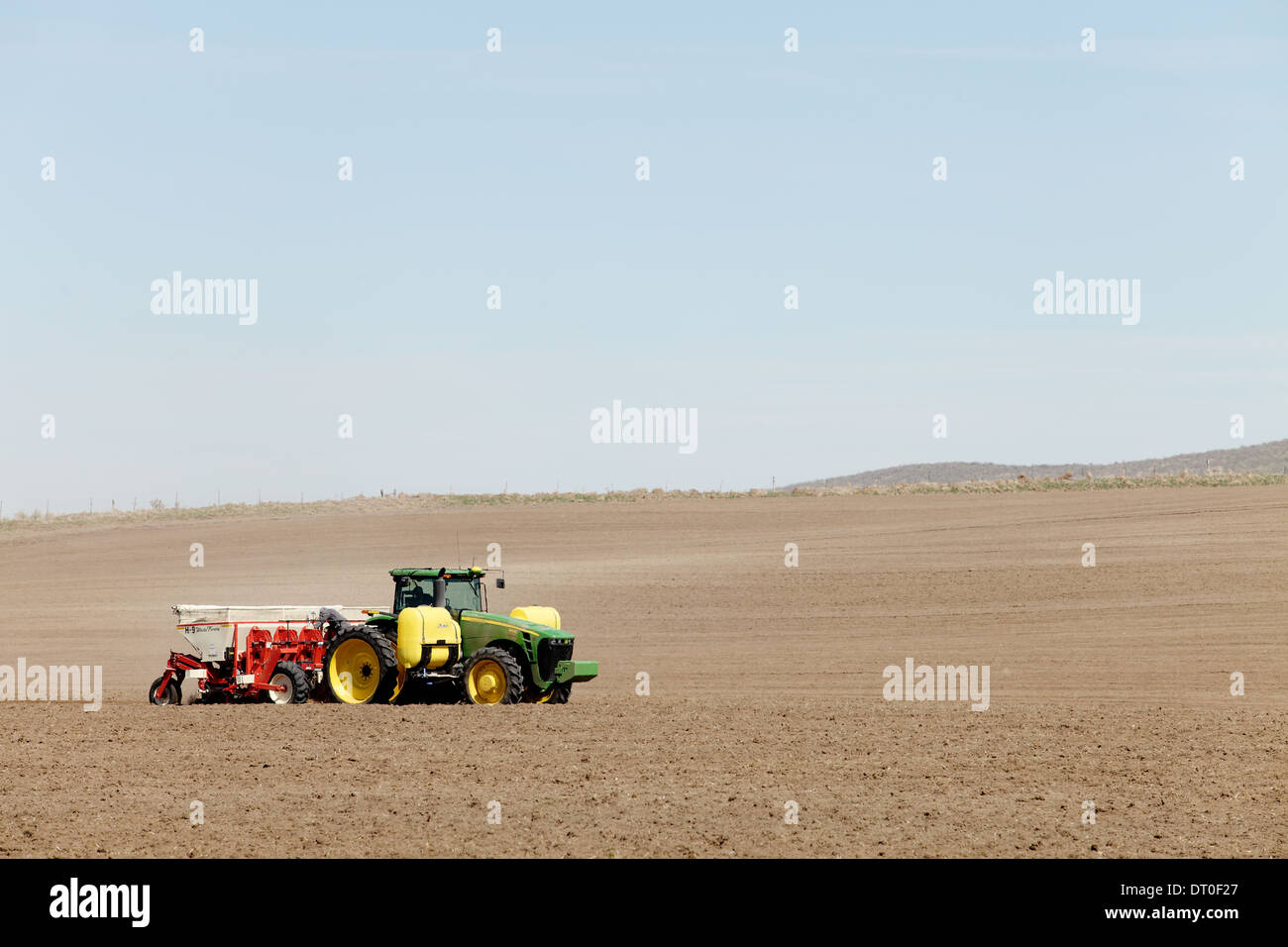 Tractors and other farm machinery working in the fields planting Famous Idaho Potatoes. Stock Photo