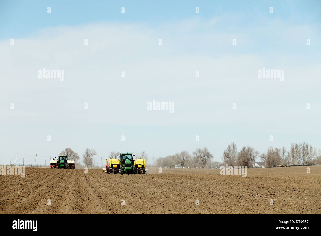 Tractors and other farm machinery working in the fields planting Famous