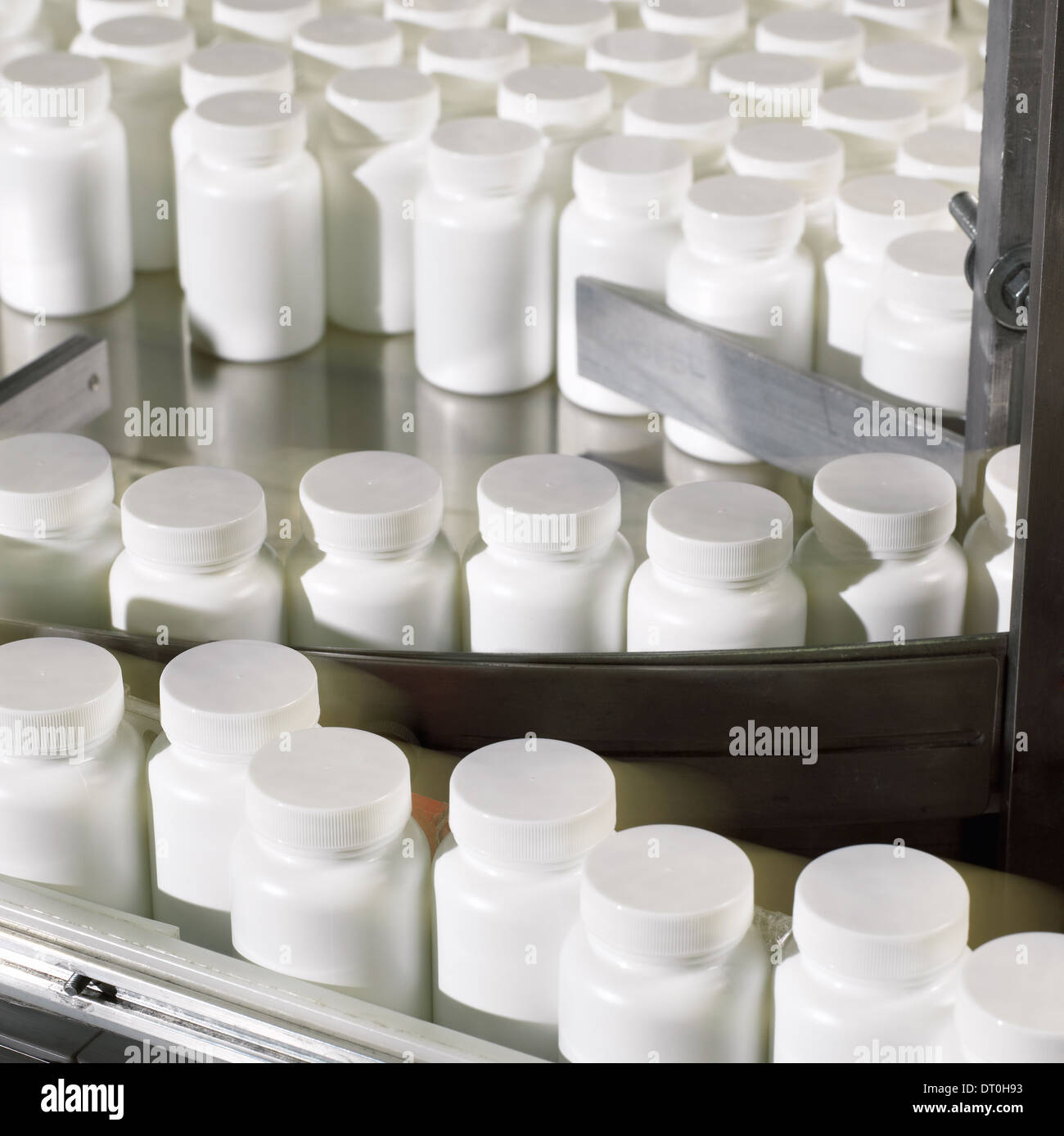 Bottles preparing to be labeled in a pharmaceutical processing facility ...