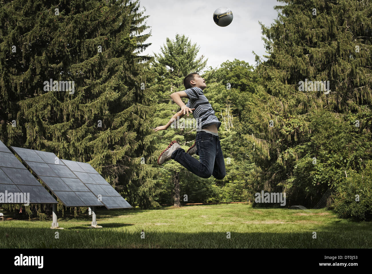 Woodstock New York USA boy leaping to head ball in garden Stock Photo