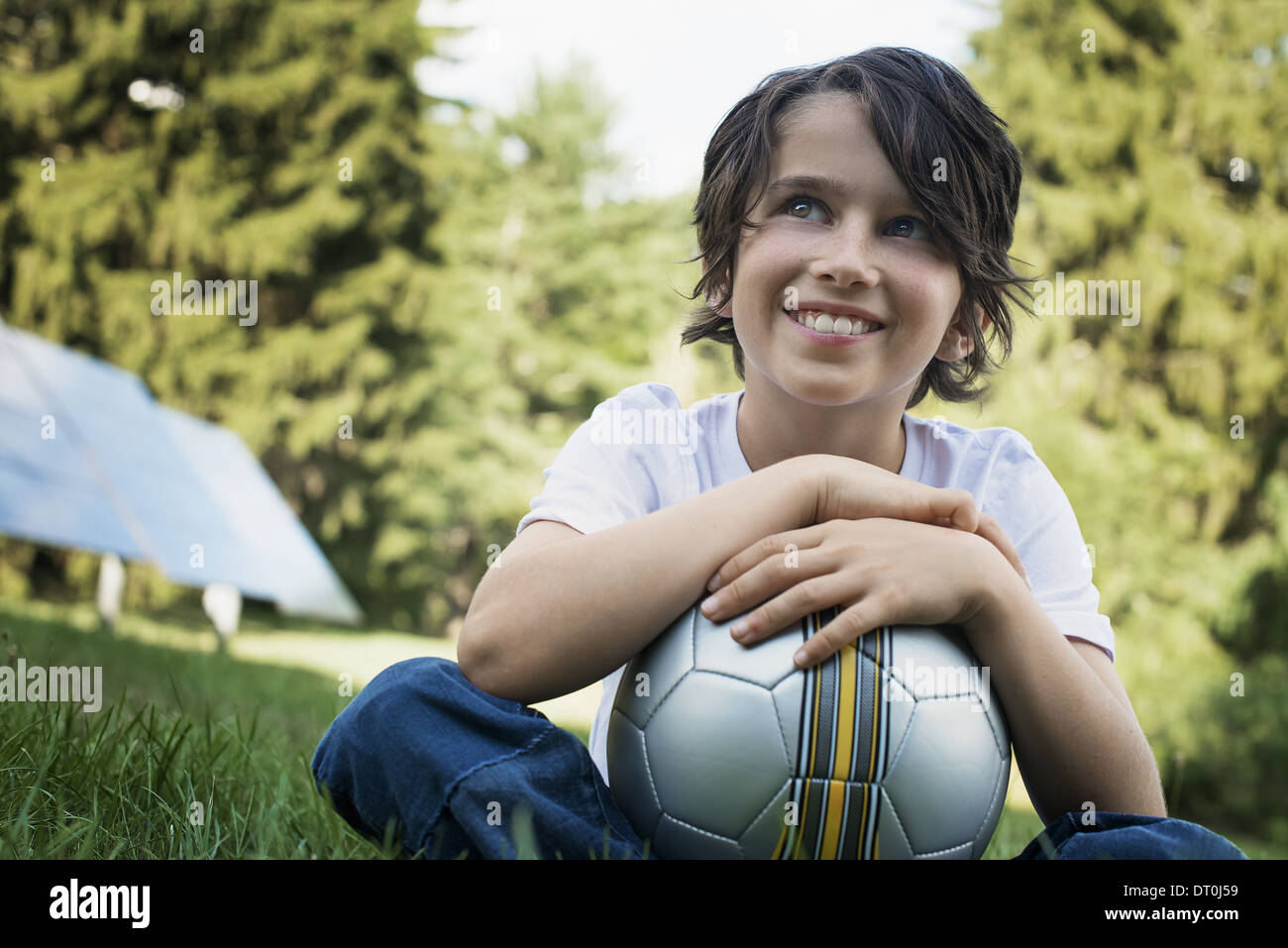 Woodstock New York USA boy holding football sitting on grass Solar panel Stock Photo