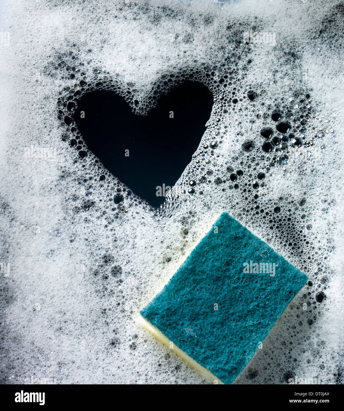 Heart shape in soap suds with green scourer Stock Photo