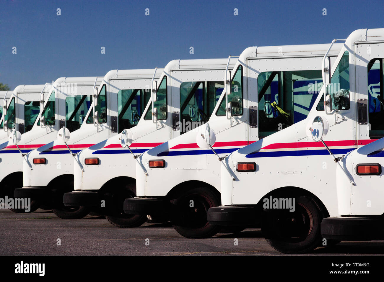 A row of US Postal service trucks parked waiting to deliver the mail. Stock Photo