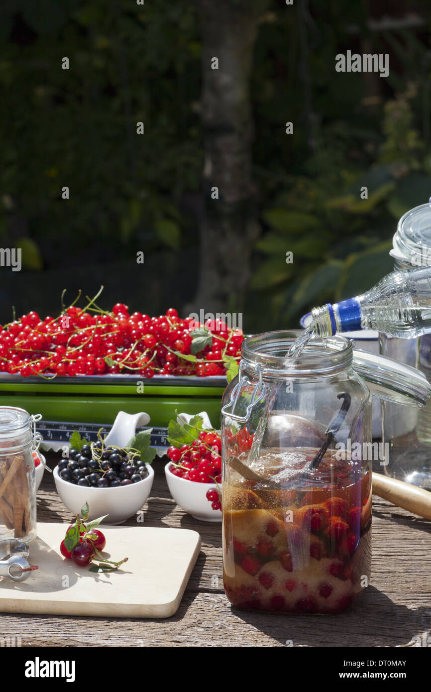 Cherry liqueur preparation, step 6, filling vodka in a canning jar with