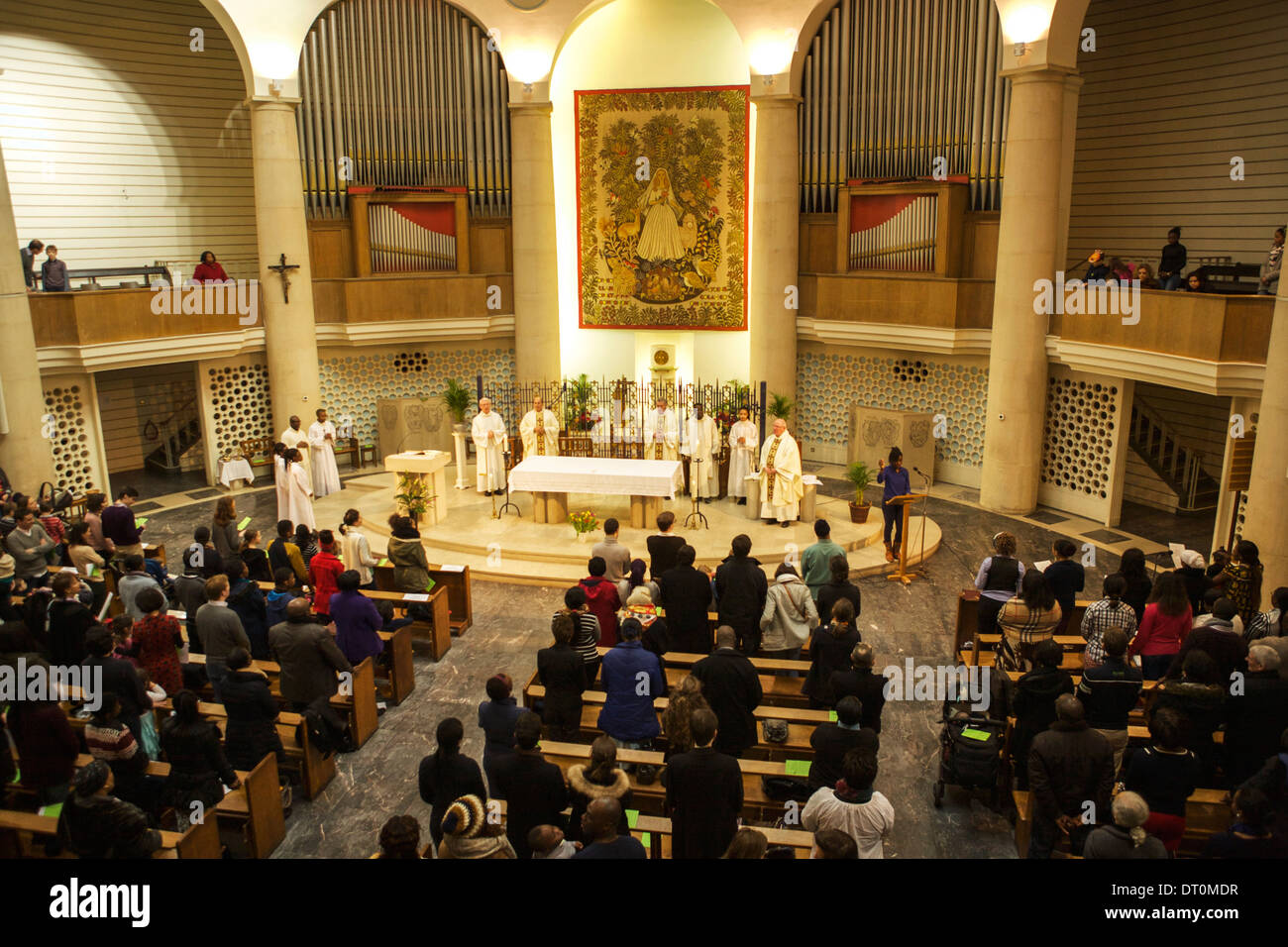 Religious service with priests and congregation in a church in central London: The Roman Catholic Church of Notre Dame De France Stock Photo