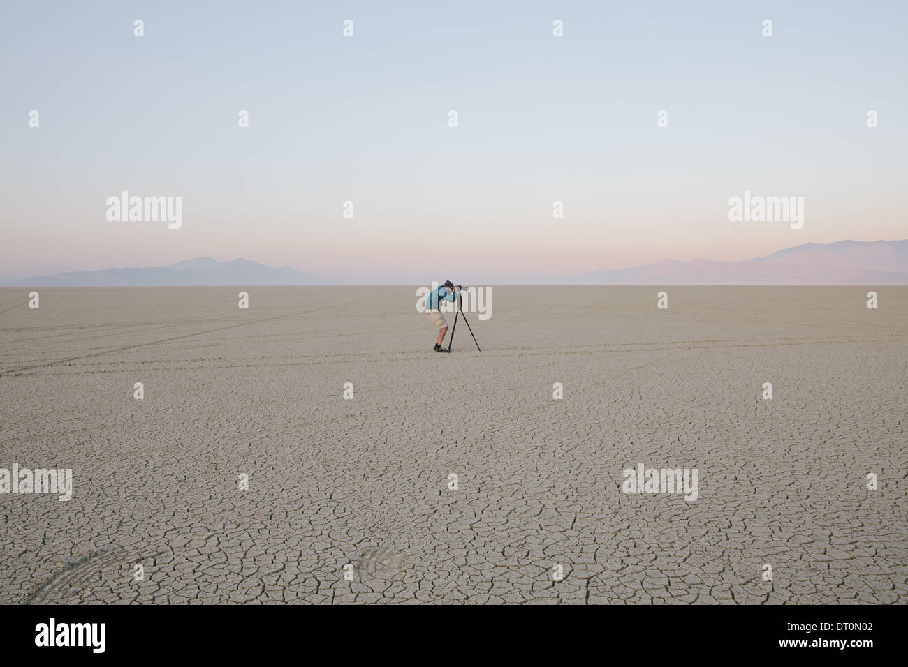 Black Rock Desert Nevada USA Man with camera tripod on flat saltpan or playa Stock Photo