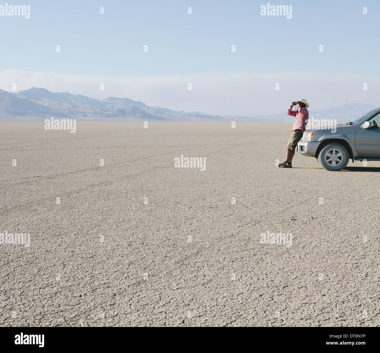 Black Rock Desert Nevada USA man leaning truck looking through binoculars Stock Photo