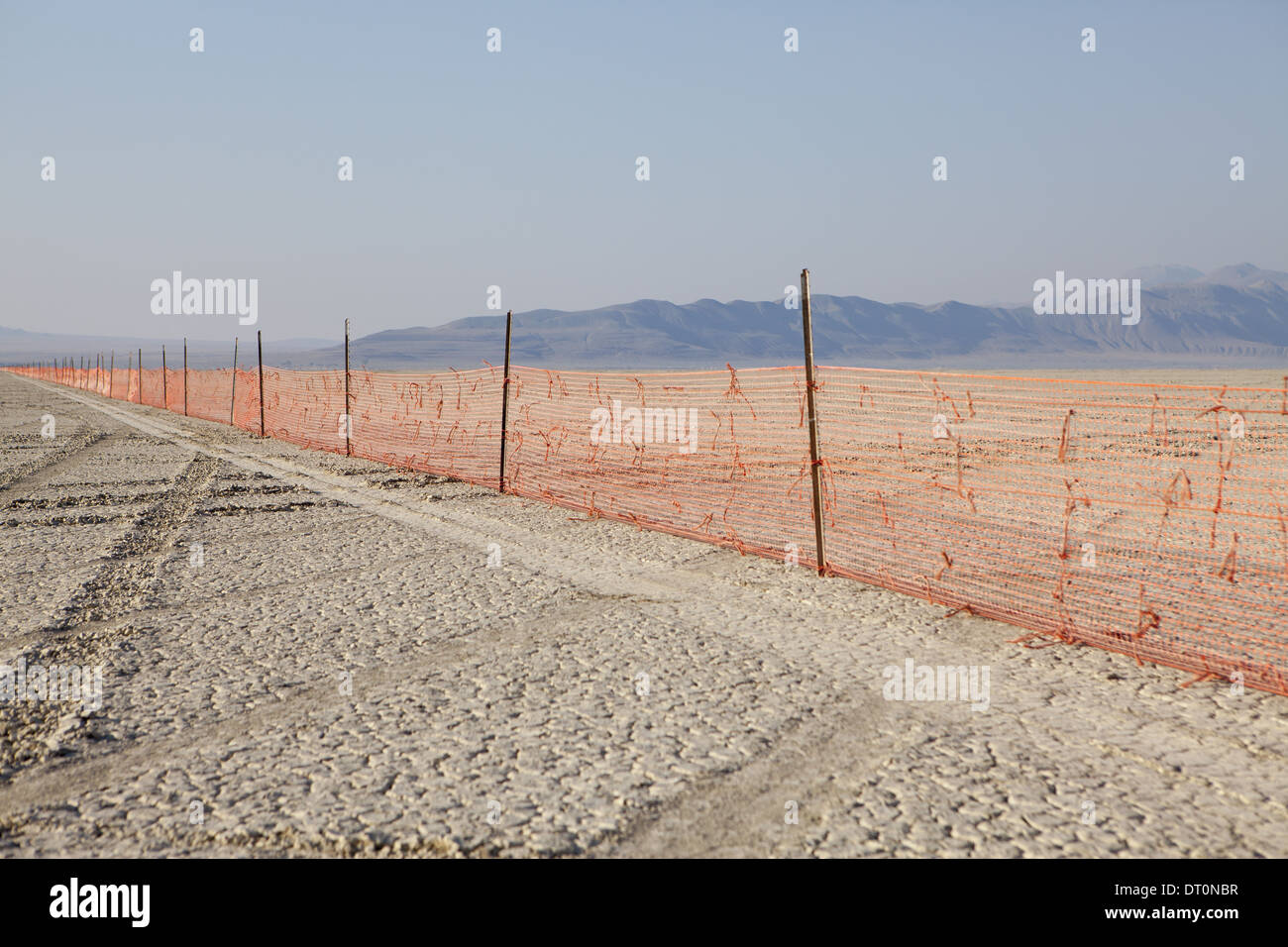 Black Rock Desert Nevada USA Fence barricade extending across flat landscape Stock Photo