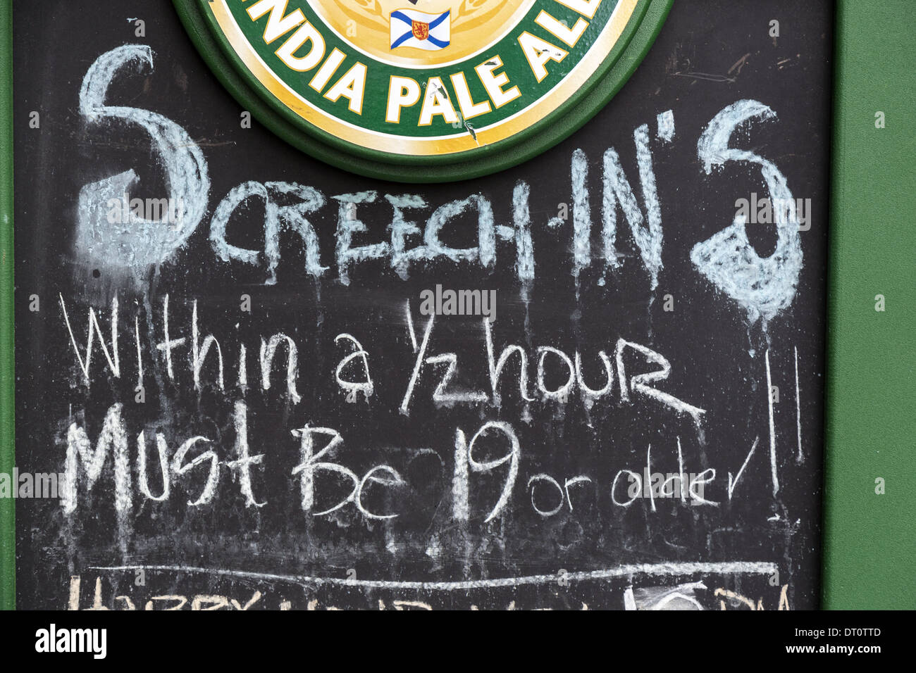 Sign outside a bar in George Street St Johns Newfoundland offering Screech-Ins an initiation ceremony. The person must drink screech rum, kiss a cod Stock Photo