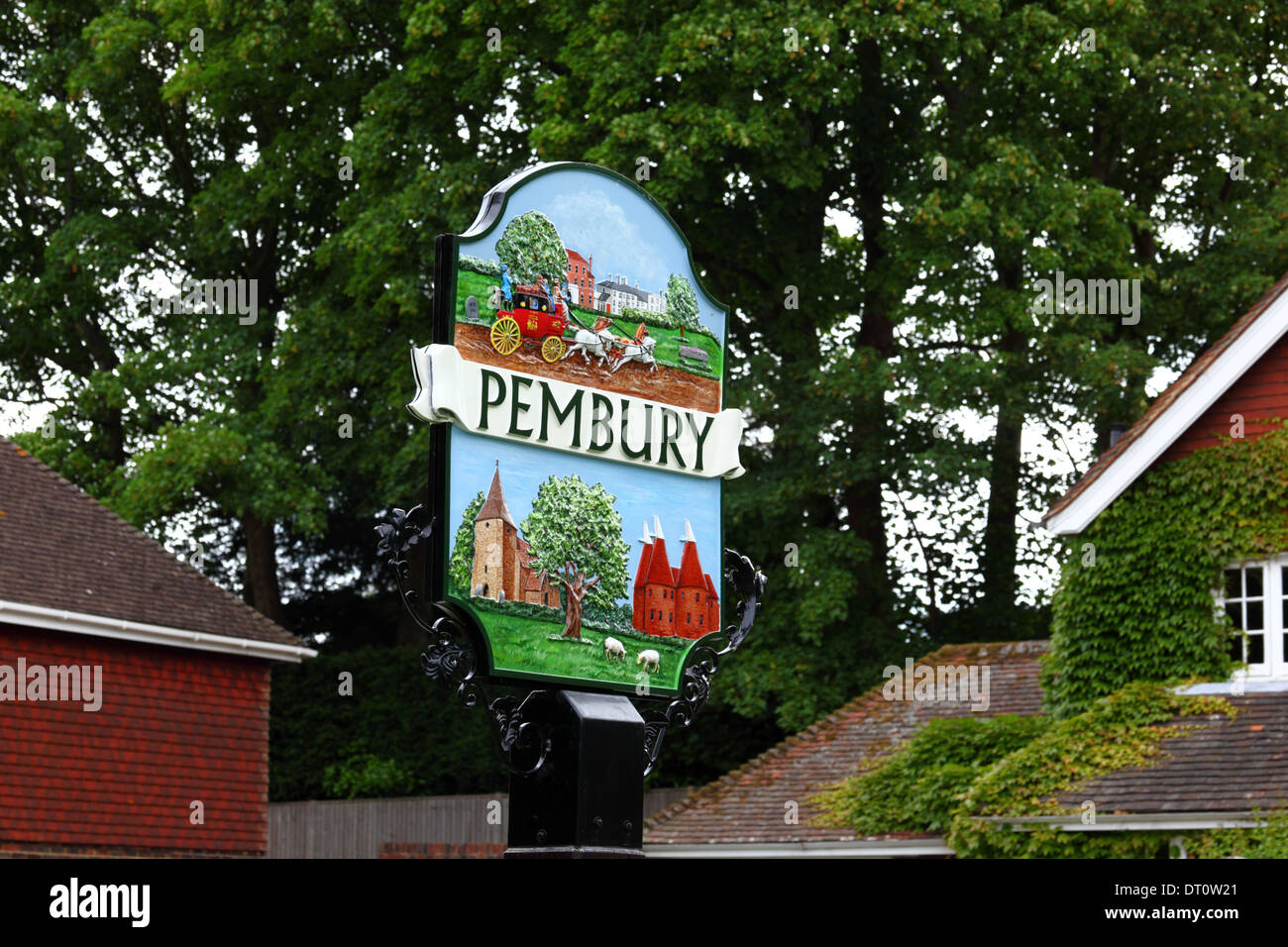 Painted ornamental village sign with typical local faming scenes and old parish church on the village green, Pembury, Kent , England Stock Photo