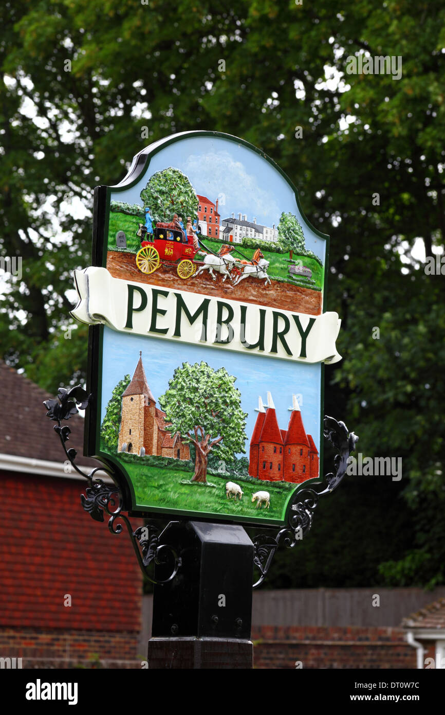 Painted ornamental village sign with typical local faming scenes and old parish church on the village green, Pembury, Kent , England Stock Photo