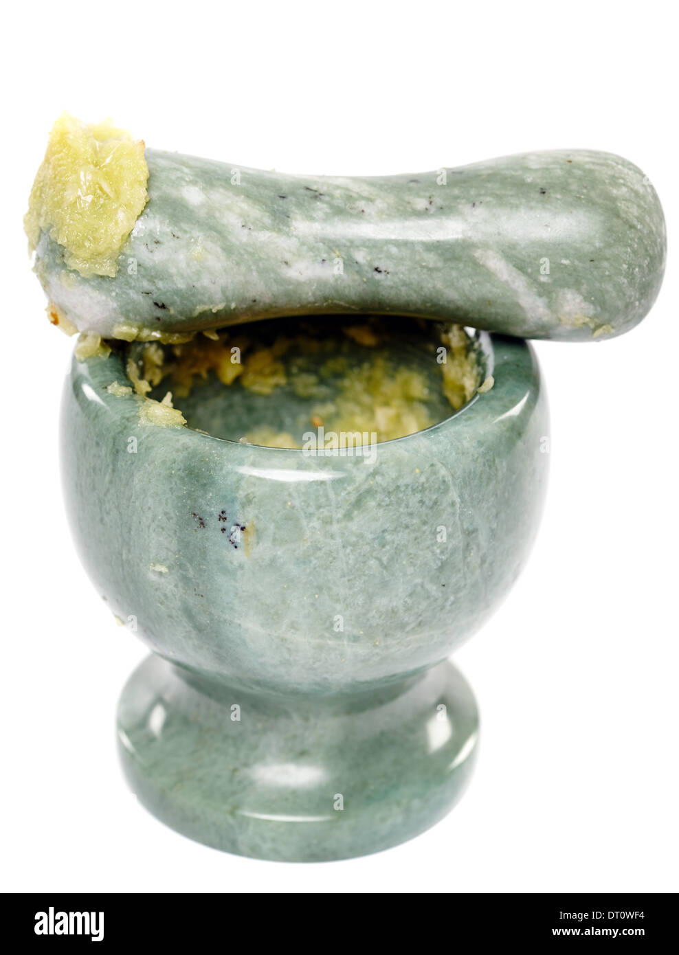 Closeup of crushed garlic in the mortar and on the pestle, isolated