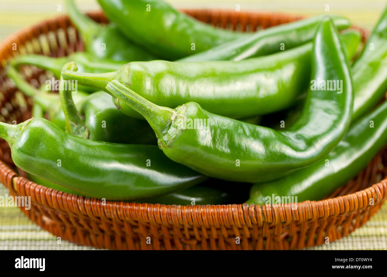 Closeup horizontal photo of fresh Korean Green Peppers in basket with textured table cloth underneath Stock Photo