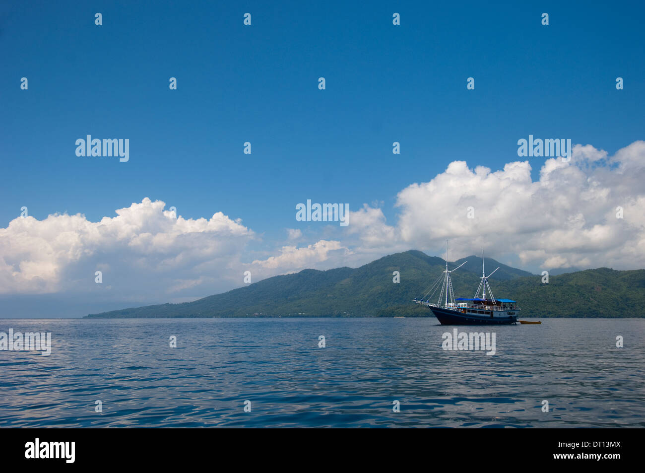 Dive boat with hills in background, Tenate, Halmahera, Maluku Islands, Indonesia Stock Photo