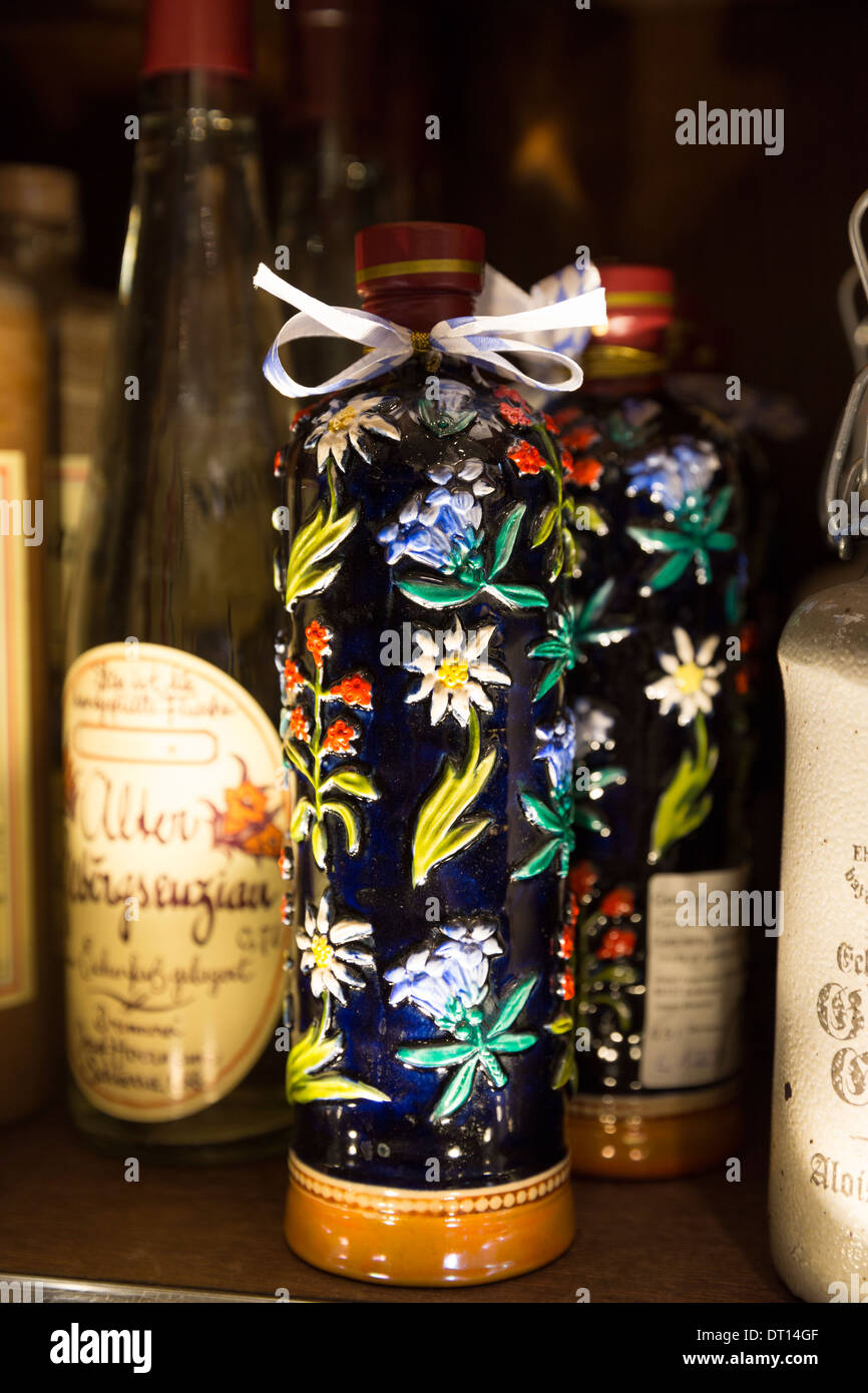 Gentian Brandy, a Bavarian speciality, in floral bottle on display at Dallmayr food store in Munich, Bavaria, Germany Stock Photo