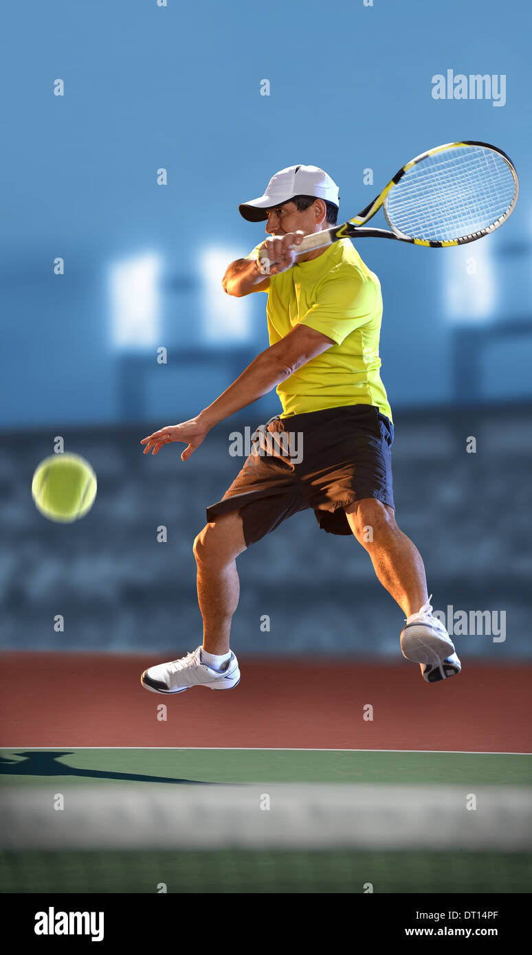 Tennis Player in Action inside court at night Stock Photo