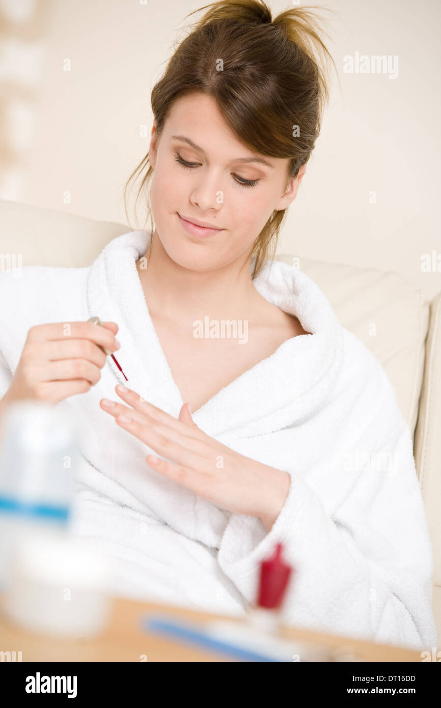 Body care - woman polish nail in bathrobe Stock Photo
