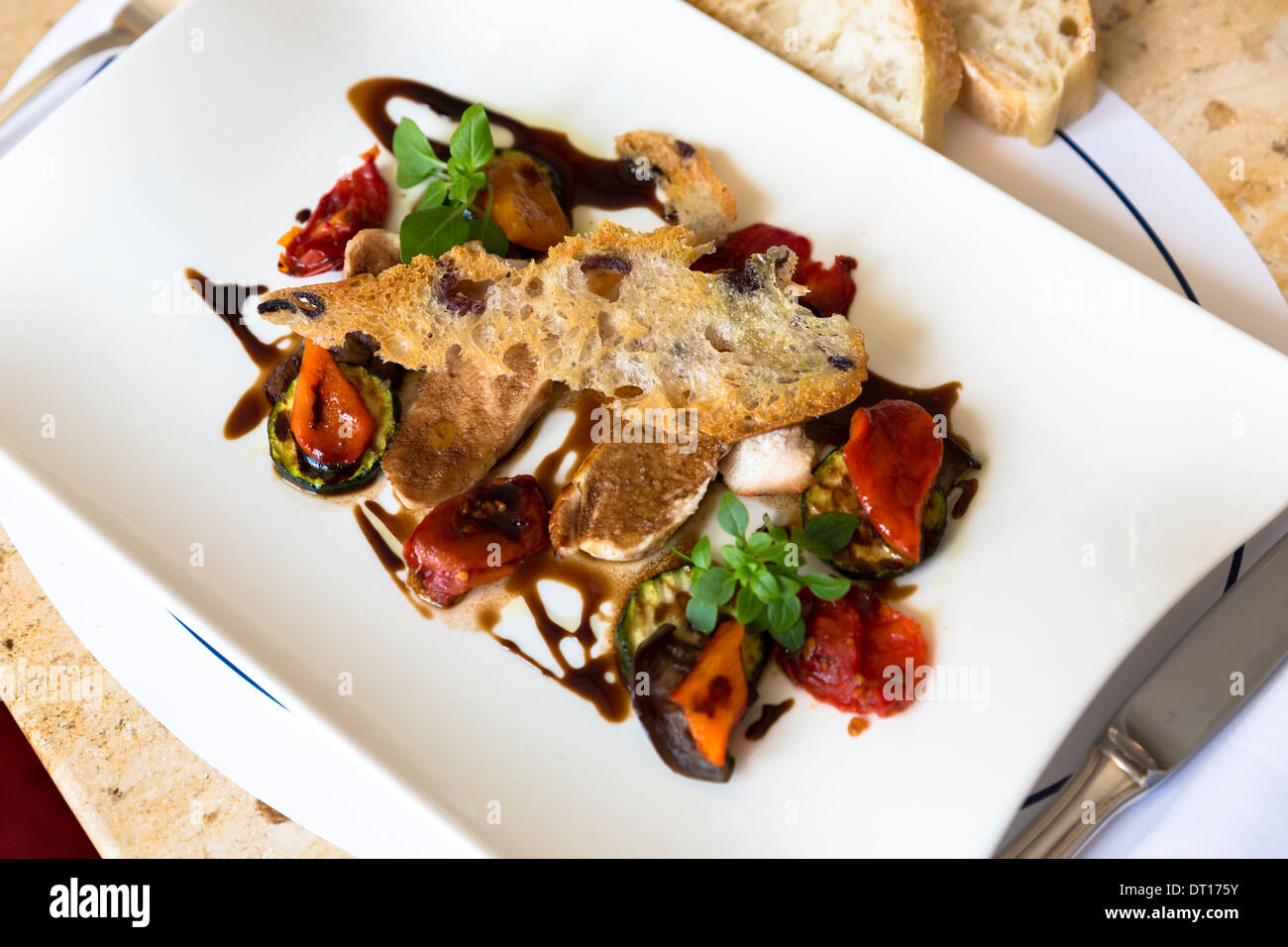 Meal of lamb with roasted vegetables and balsamic vinegar in Cafe