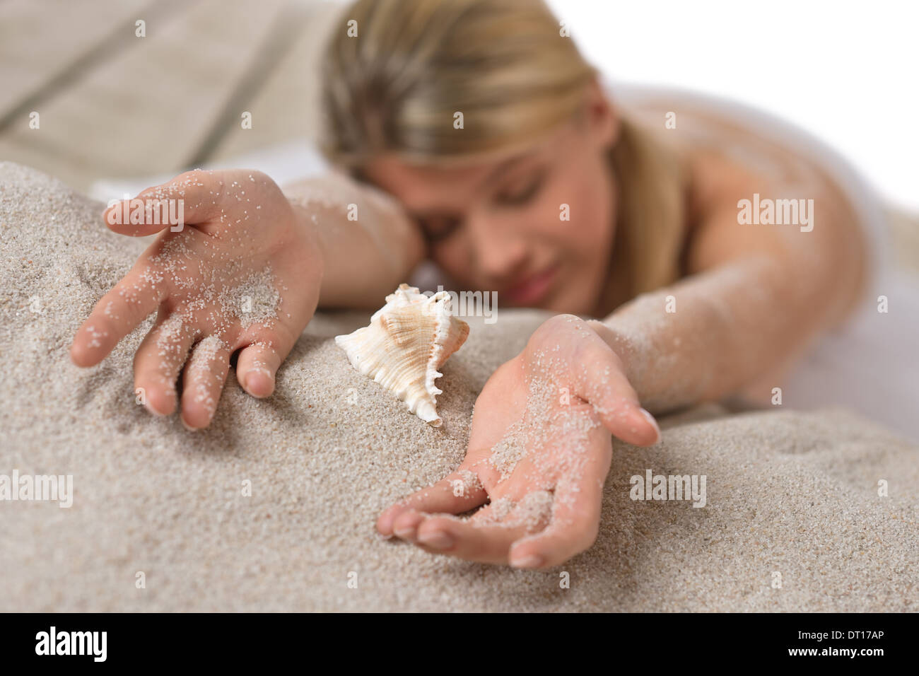 Beach - woman with shell lying in sand Stock Photo