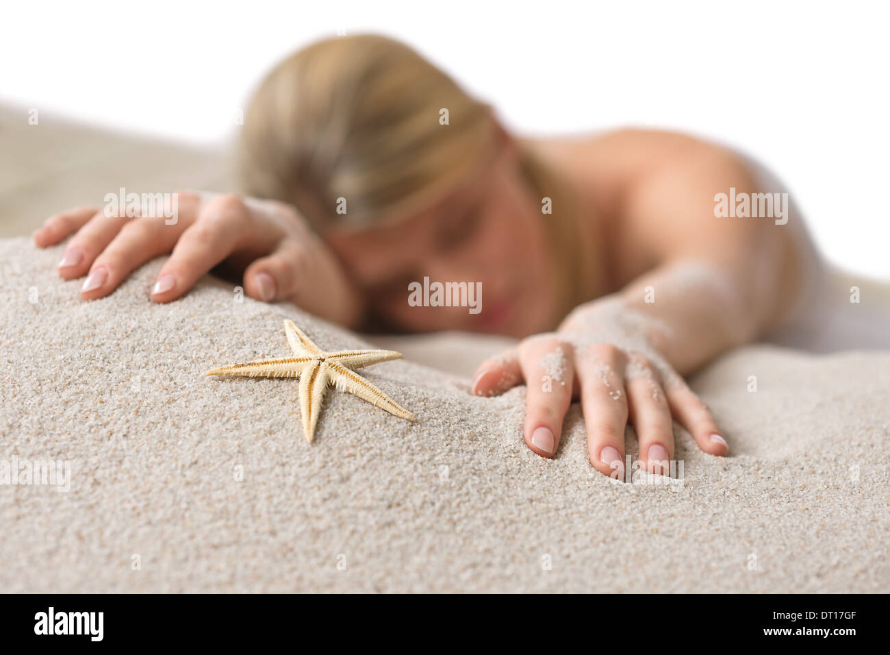 Beach - woman with starfish lying in sand Stock Photo