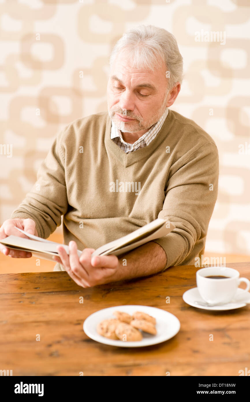 Senior mature man reading book having coffee Stock Photo