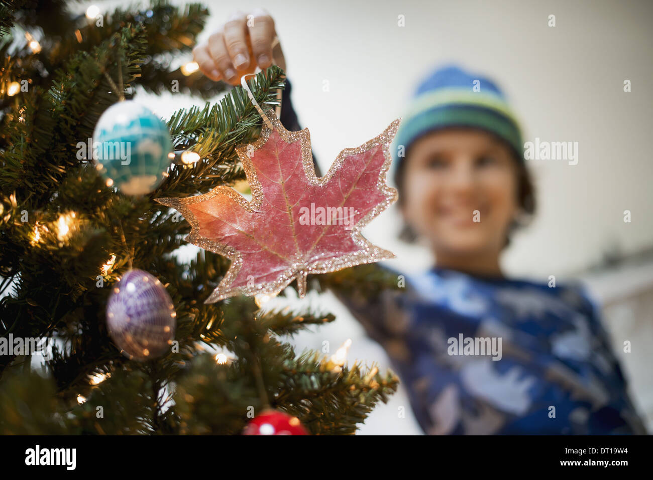 Woodstock New York USA boy placing Christmas ornaments on tree Stock Photo