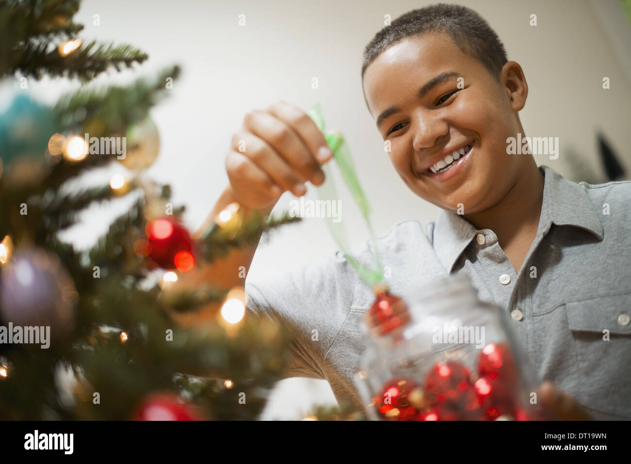 Woodstock New York USA boy placing Christmas ornaments on tree Stock Photo