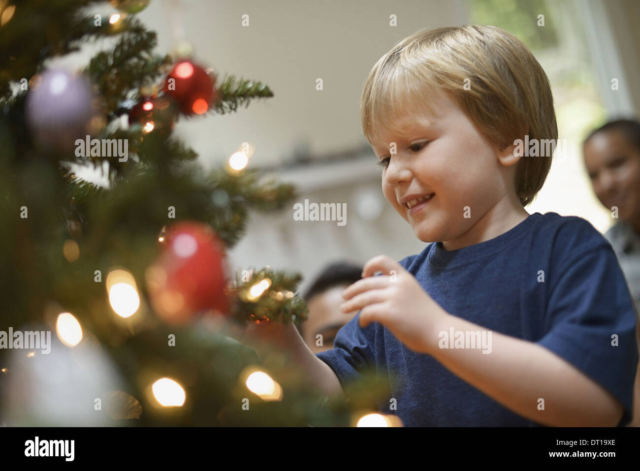 Woodstock New York USA boy placing Christmas ornaments on tree Stock Photo